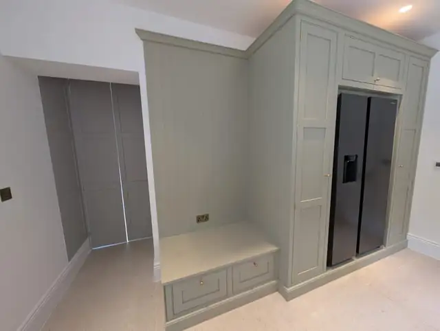 Bespoke sage green larder unit with a built-in bench seat
