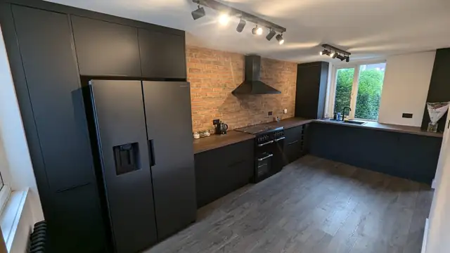 Black kitchen with tall housing and American fridge freezer